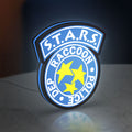 Raccoon City STARS LED lightbox standing on a desk from an angled side view with blue glow