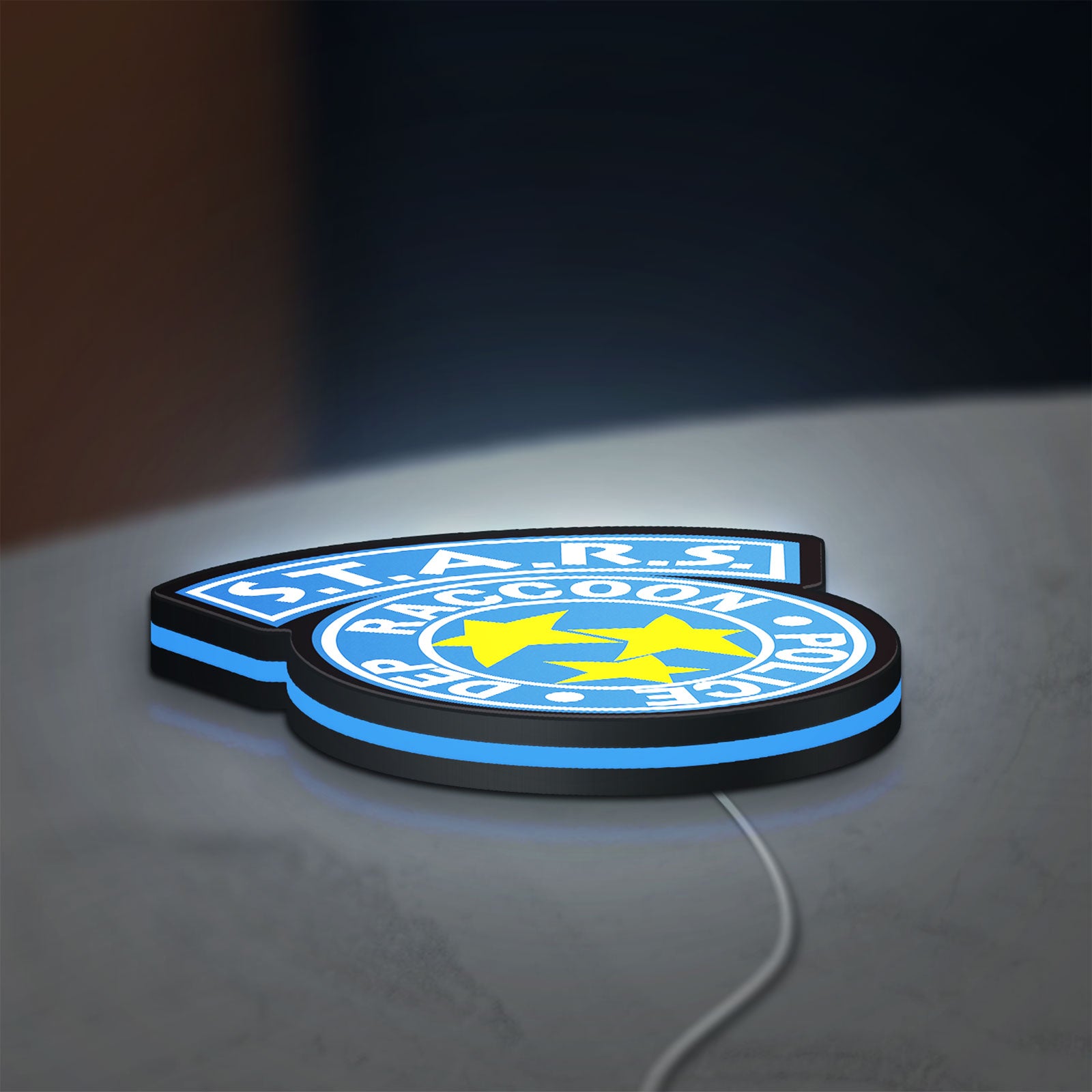 Raccoon City STARS LED lightbox lying flat on a desk with blue glow