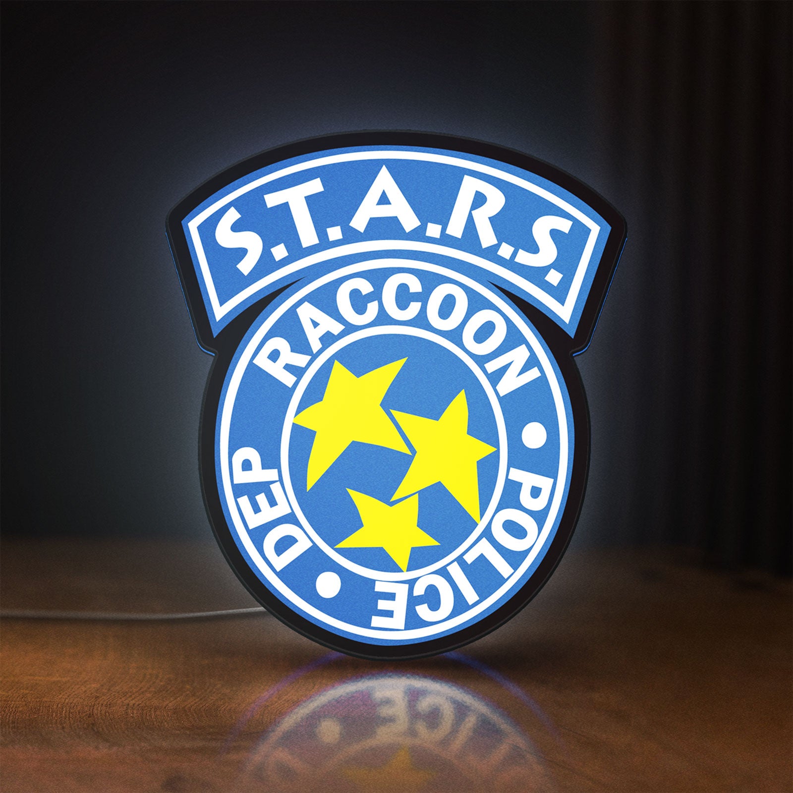 Front view of Raccoon City STARS LED lightbox sign glowing on a wooden desk
