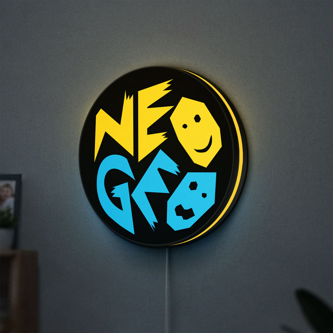 SNK NeoGeo LED lightbox hanging on a wall with yellow glow
