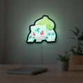 Bulbasaur LED lightbox hanging on a room wall with soft green light