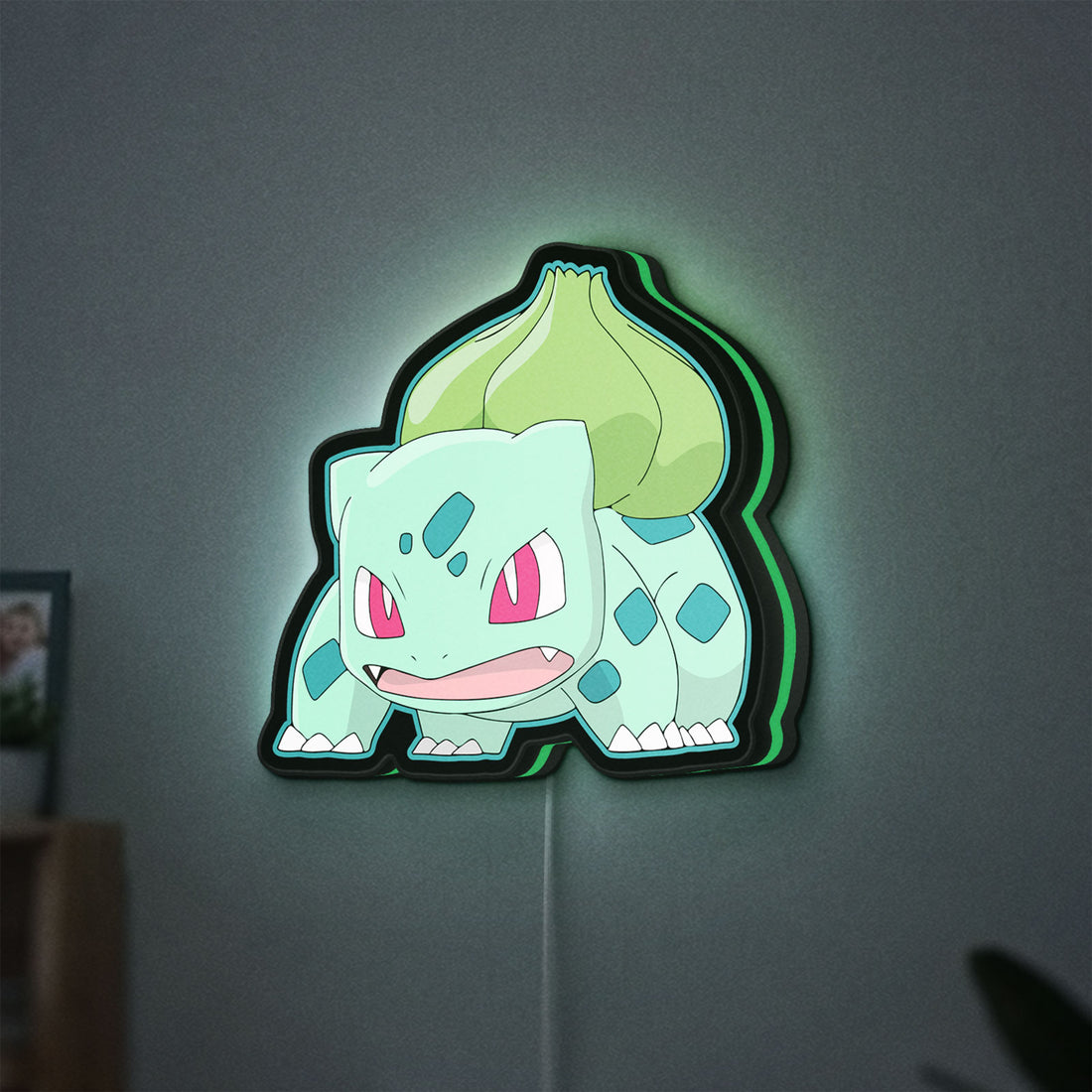 Bulbasaur LED lightbox hanging on a wall with green glow