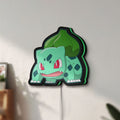 Unlit Bulbasaur LED lightbox mounted on a wall in daylight