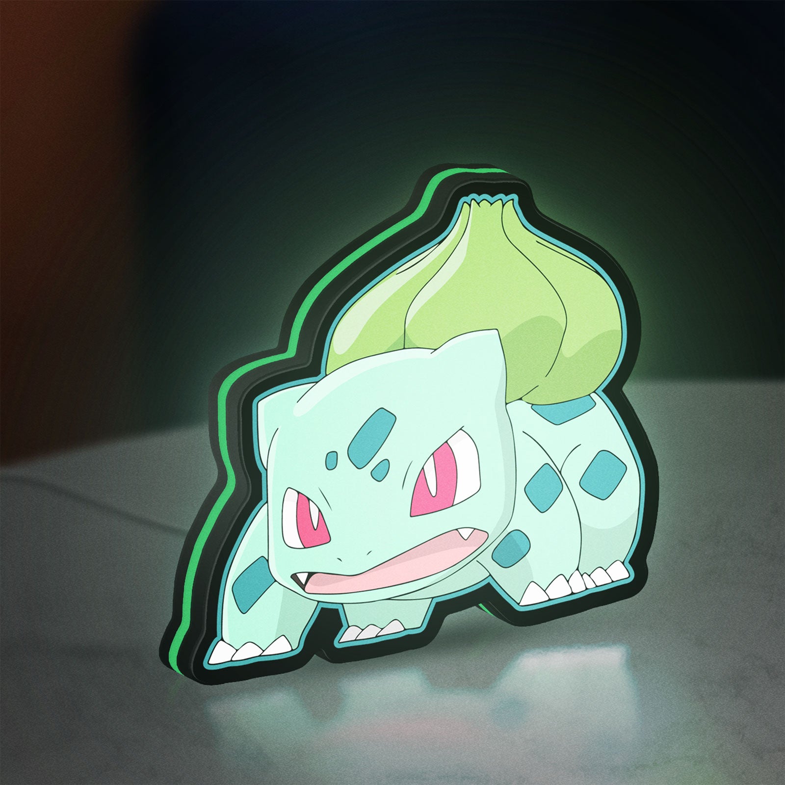 Bulbasaur LED lightbox standing on a desk from an angled side view with green glow