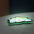 Bulbasaur LED lightbox lying flat on a desk with green glow