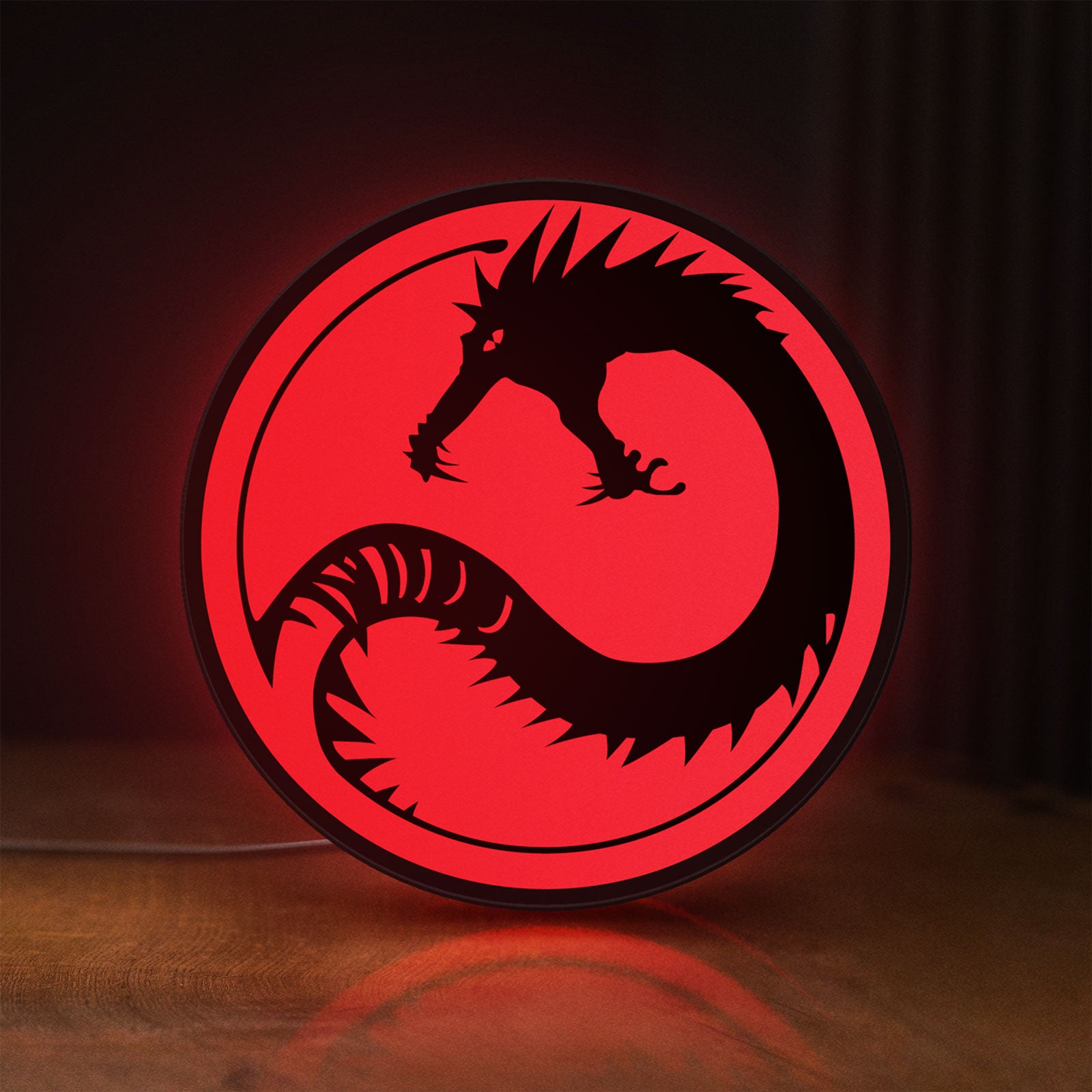 Front view of Battletech House Kurita LED lightbox sign glowing on a wooden desk