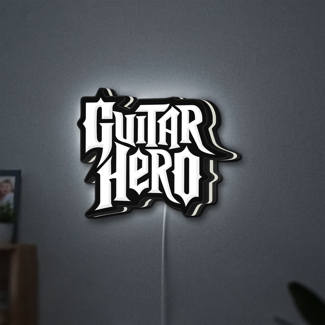 Guitar Hero LED lightbox hanging on a wall with white glow