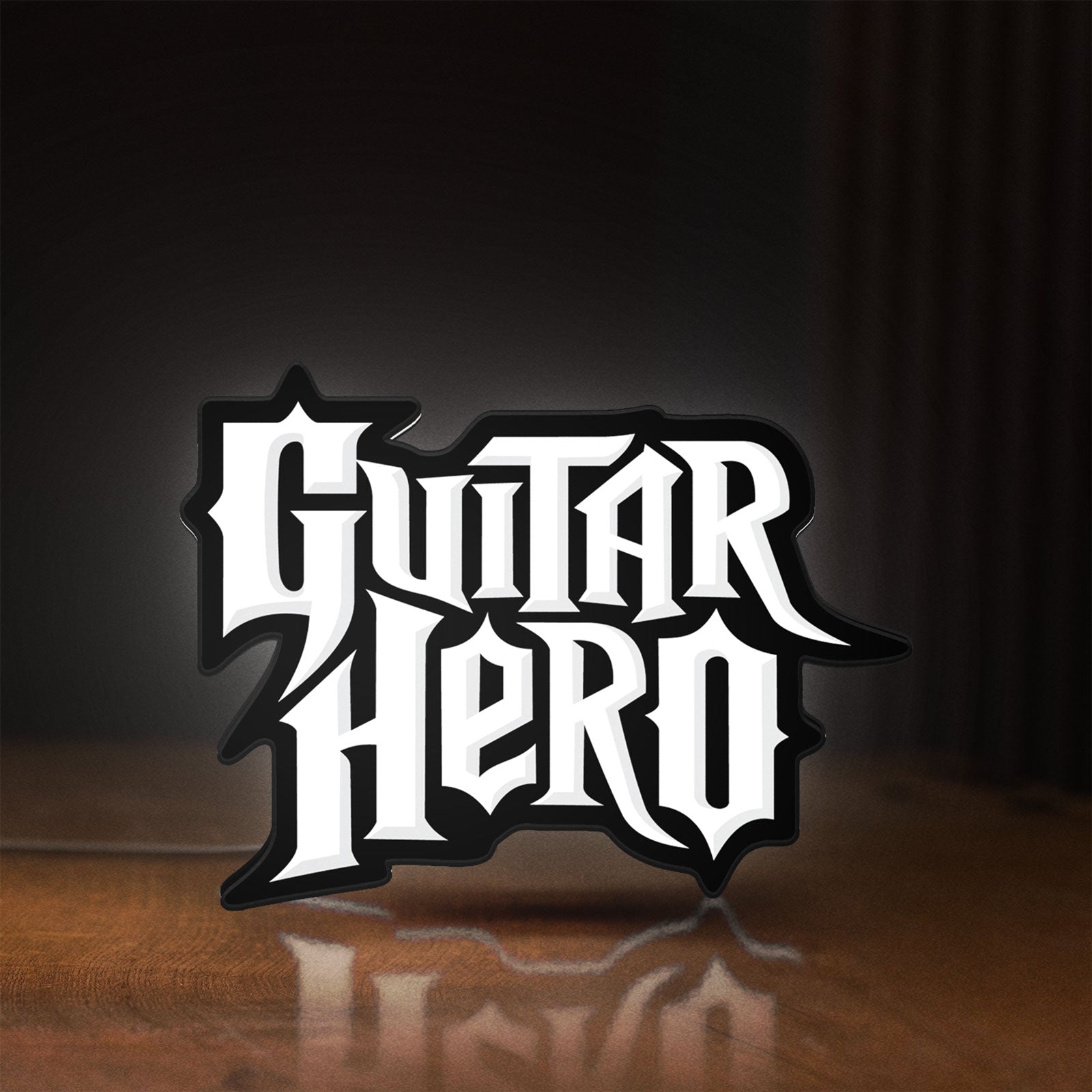 Front view of Guitar Hero LED lightbox sign glowing on a wooden desk