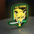 Fox Hound Special Forces LED lightbox standing on a desk from an angled side view with green glow