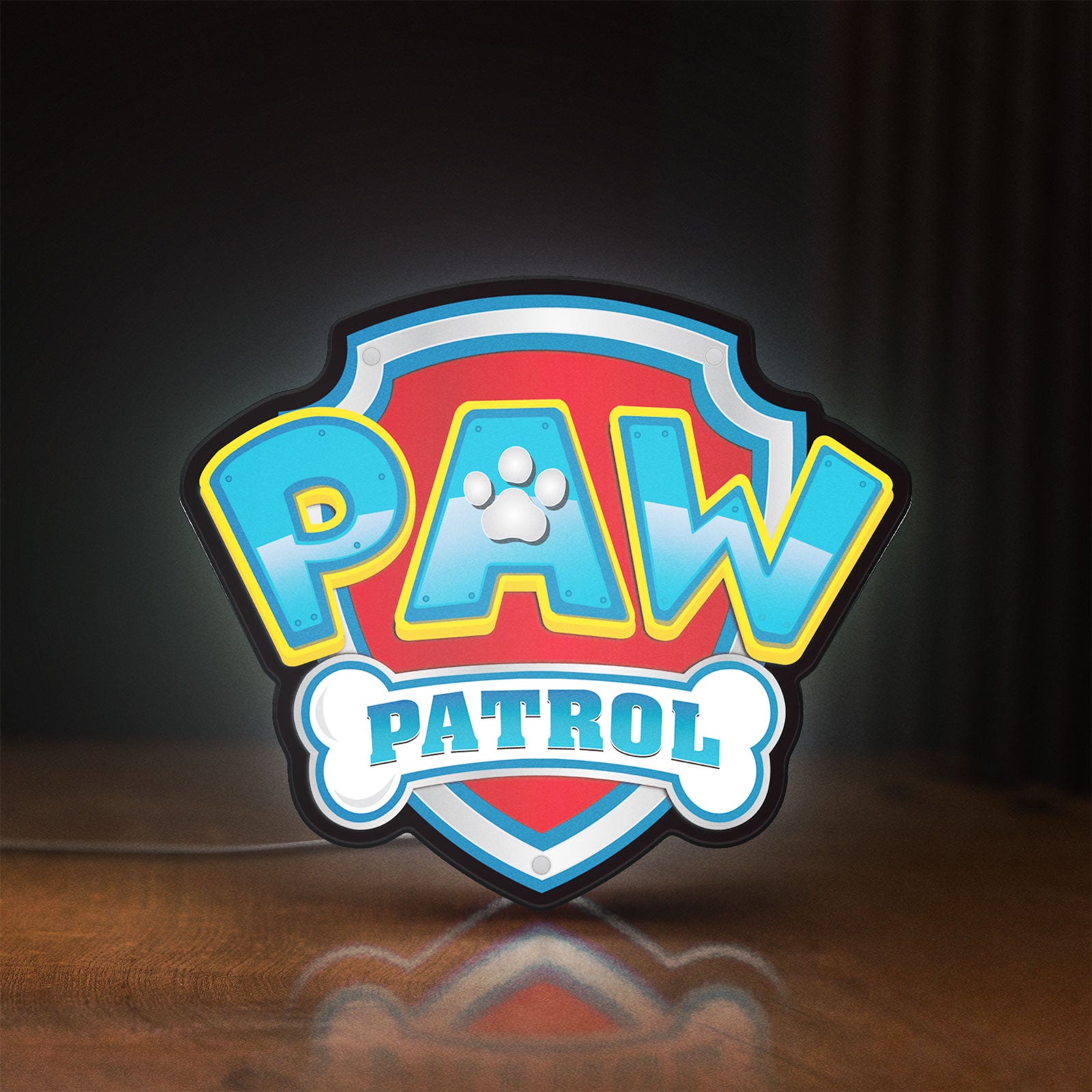Front view of Paw Patrol LED lightbox sign glowing on a wooden desk