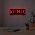 Netflix Style LED lightbox hanging on a room wall with soft red light