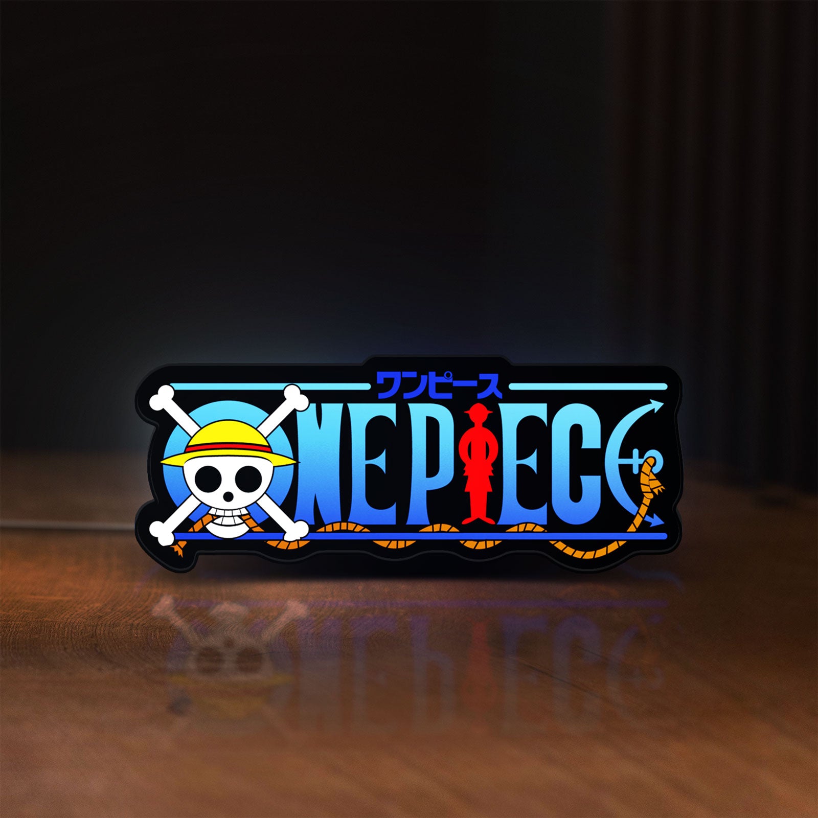 Front view of One Piece LED lightbox sign glowing on a wooden desk