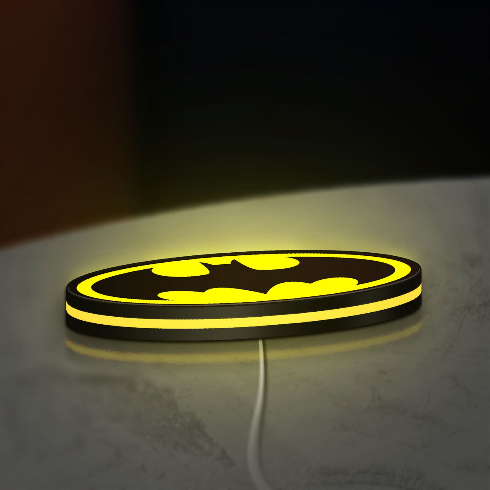 Batman LED lightbox lying flat on a desk with yellow glow