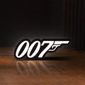 Front view of James Bond 007 LED lightbox sign glowing on a wooden desk