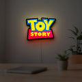 Toy Story LED lightbox hanging on a room wall with soft yellow light