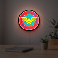 Wonder Woman LED lightbox hanging on a room wall with soft red light