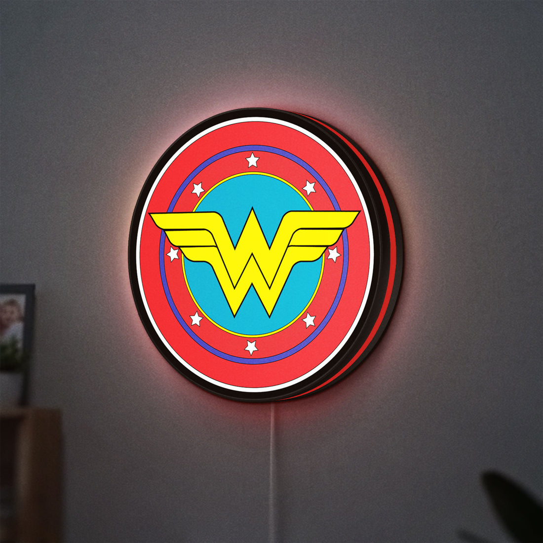 Wonder Woman LED lightbox hanging on a wall with red glow