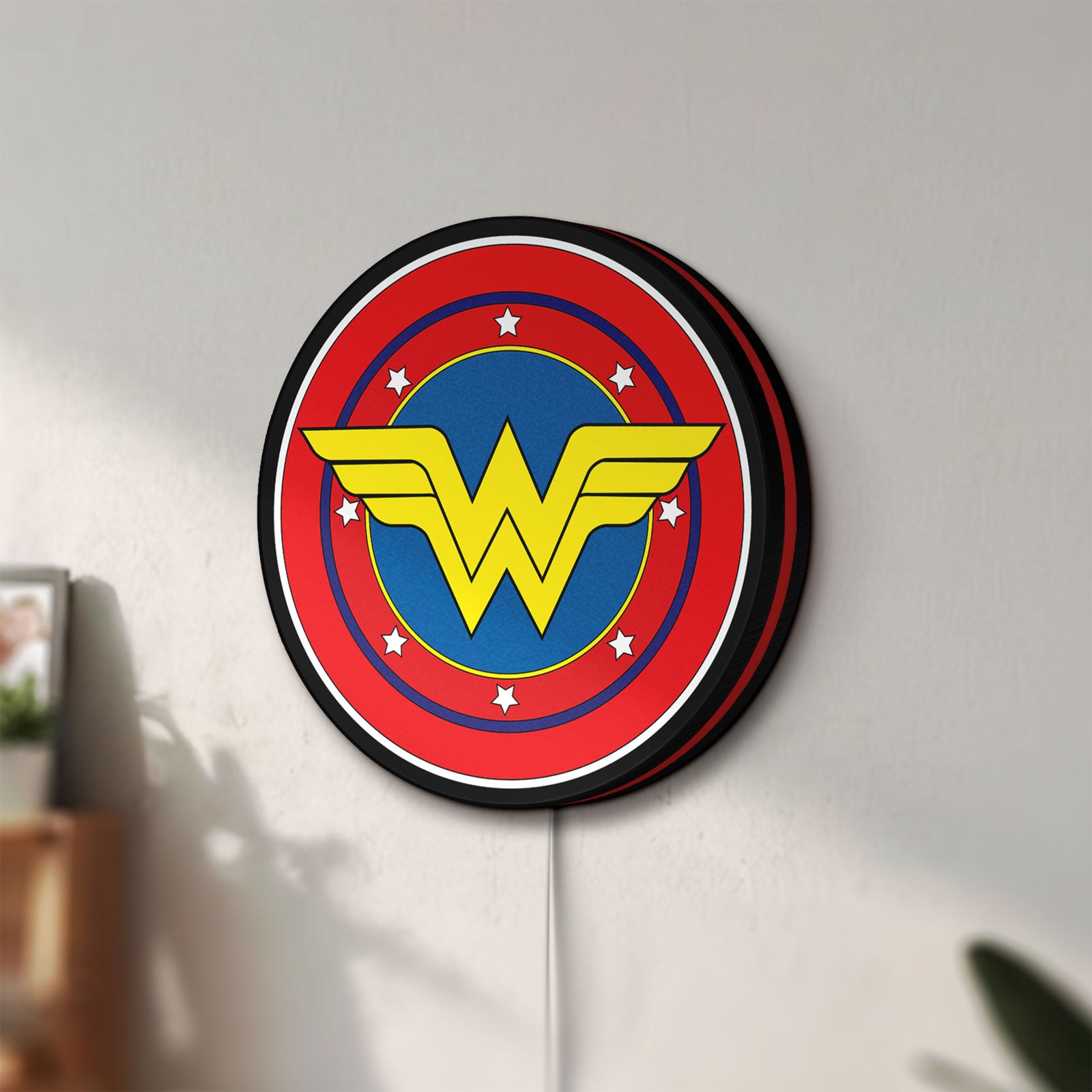 Unlit Wonder Woman LED lightbox mounted on a wall in daylight