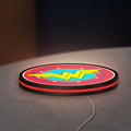 Wonder Woman LED lightbox lying flat on a desk with red glow