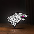 Front view of House Stark LED lightbox sign glowing on a wooden desk