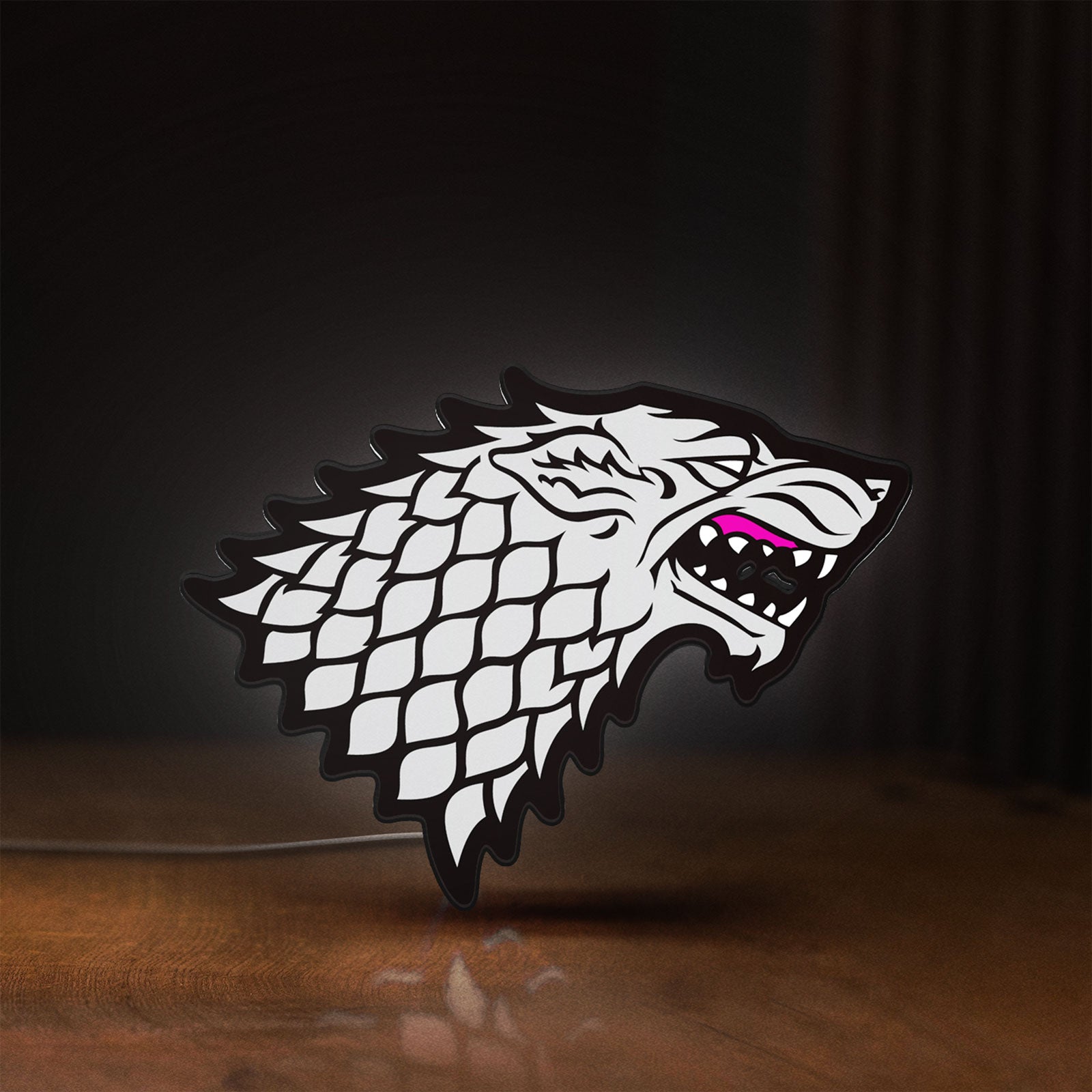 Front view of House Stark LED lightbox sign glowing on a wooden desk