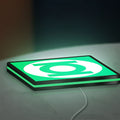 Green Lantern Corps LED lightbox lying flat on a desk with green glow
