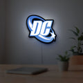 DC Comics LED lightbox hanging on a room wall with soft blue light
