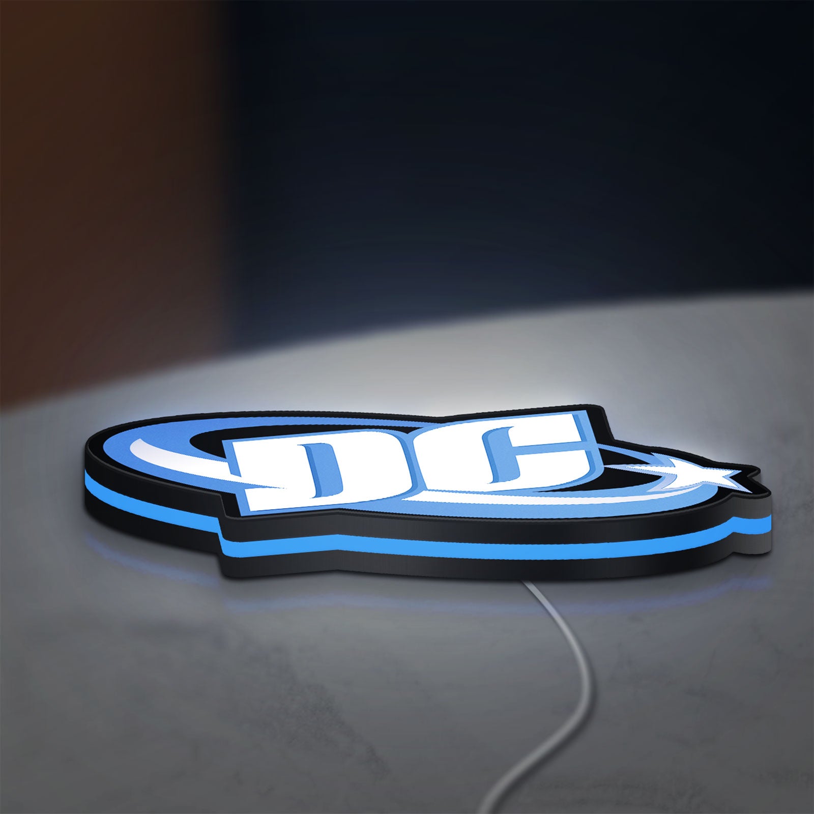 DC Comics LED lightbox lying flat on a desk with blue glow