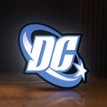 Front view of DC Comics LED lightbox sign glowing on a wooden desk