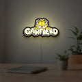 Garfield LED lightbox hanging on a room wall with soft yellow light