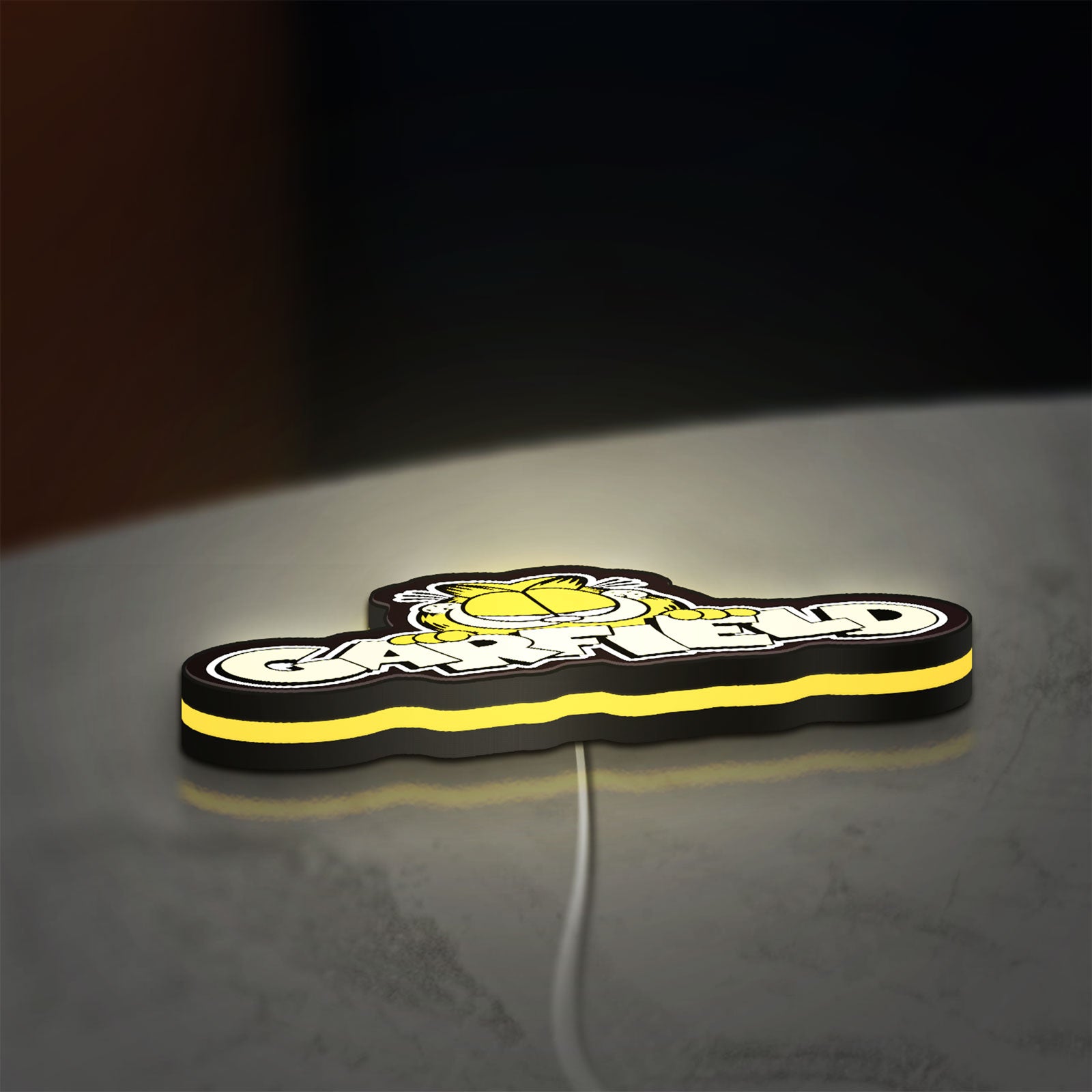 Garfield LED lightbox lying flat on a desk with yellow glow