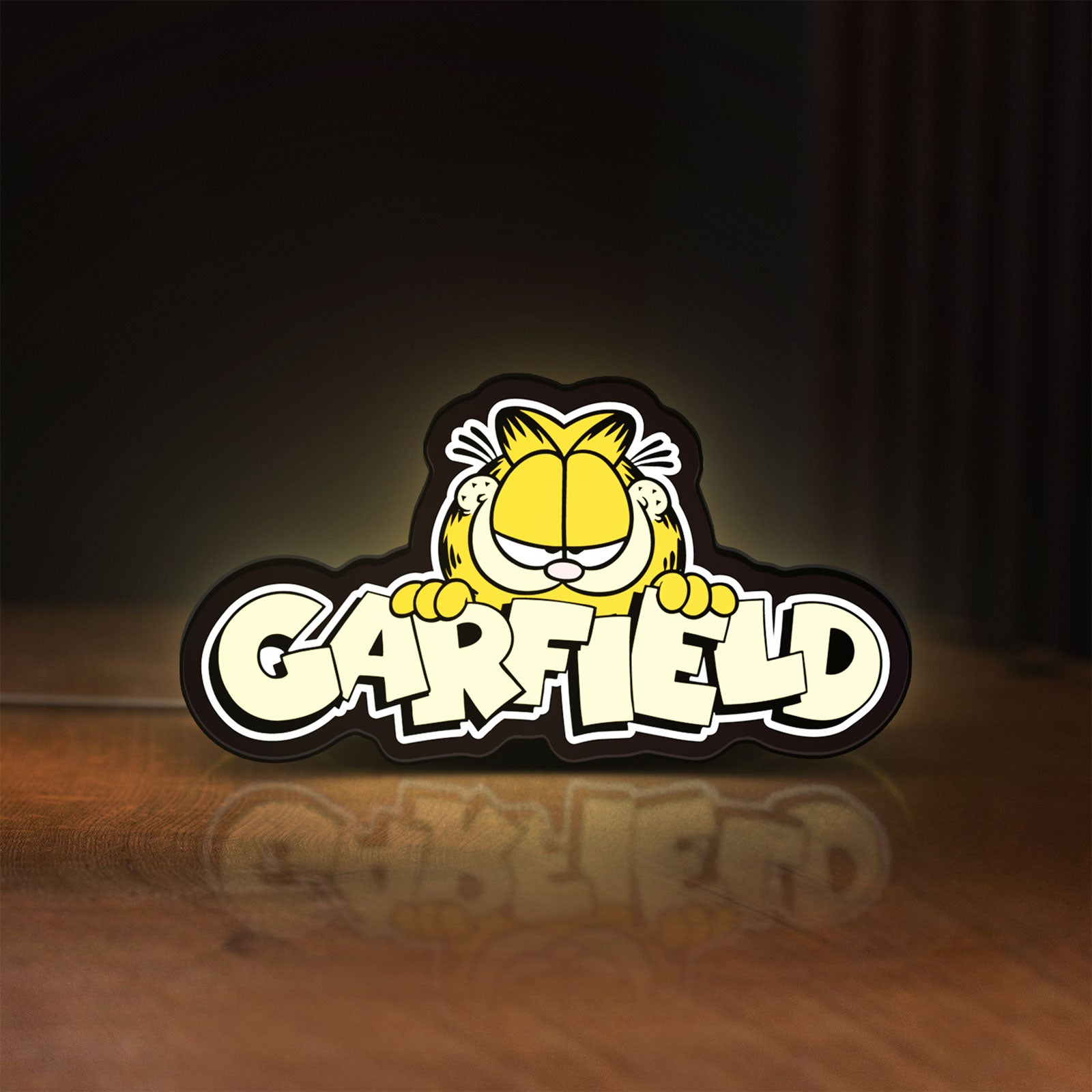 Front view of Garfield LED lightbox sign glowing on a wooden desk