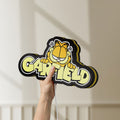 Unlit Garfield LED lightbox held by hand to show size and details