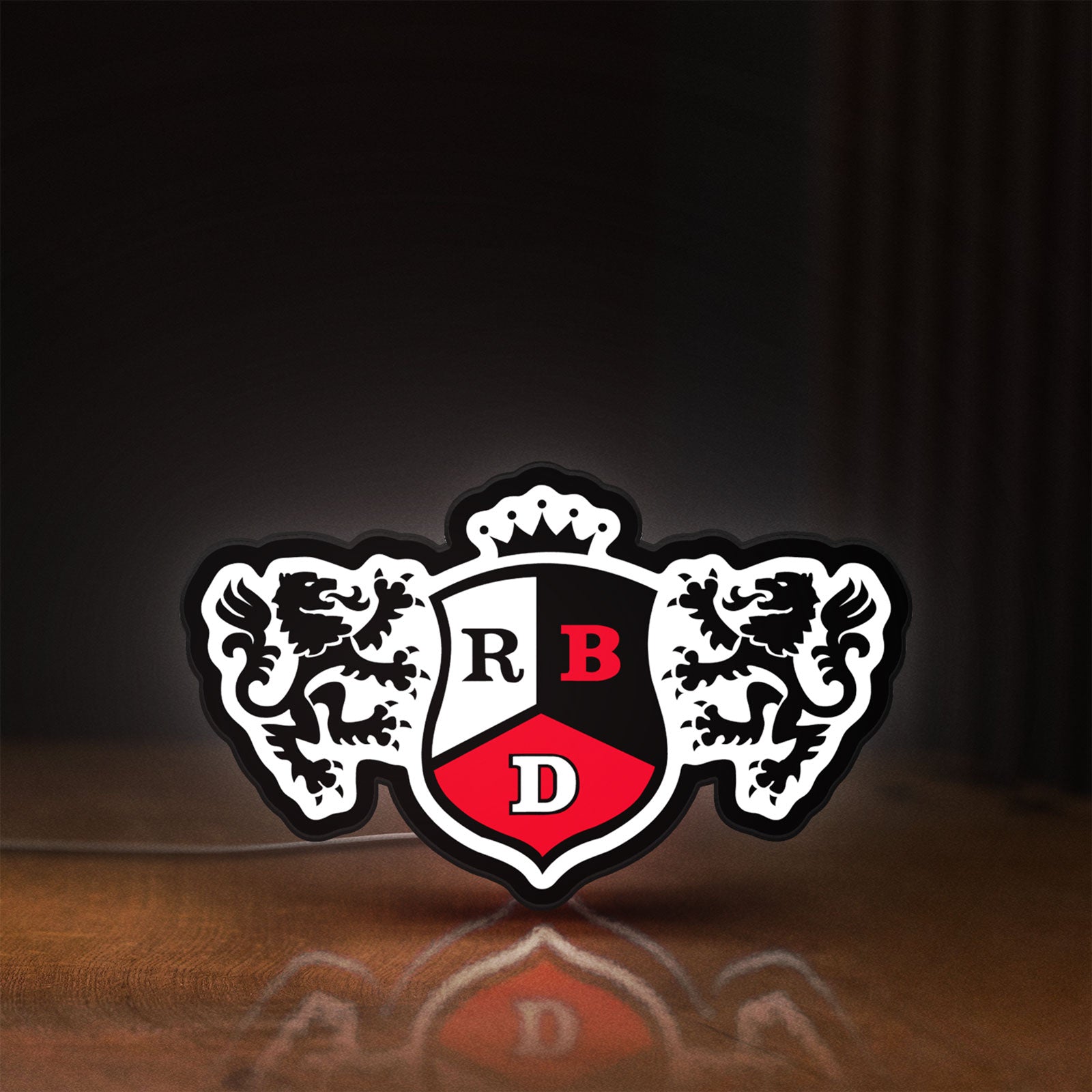 Front view of RBD LED lightbox sign glowing on a wooden desk