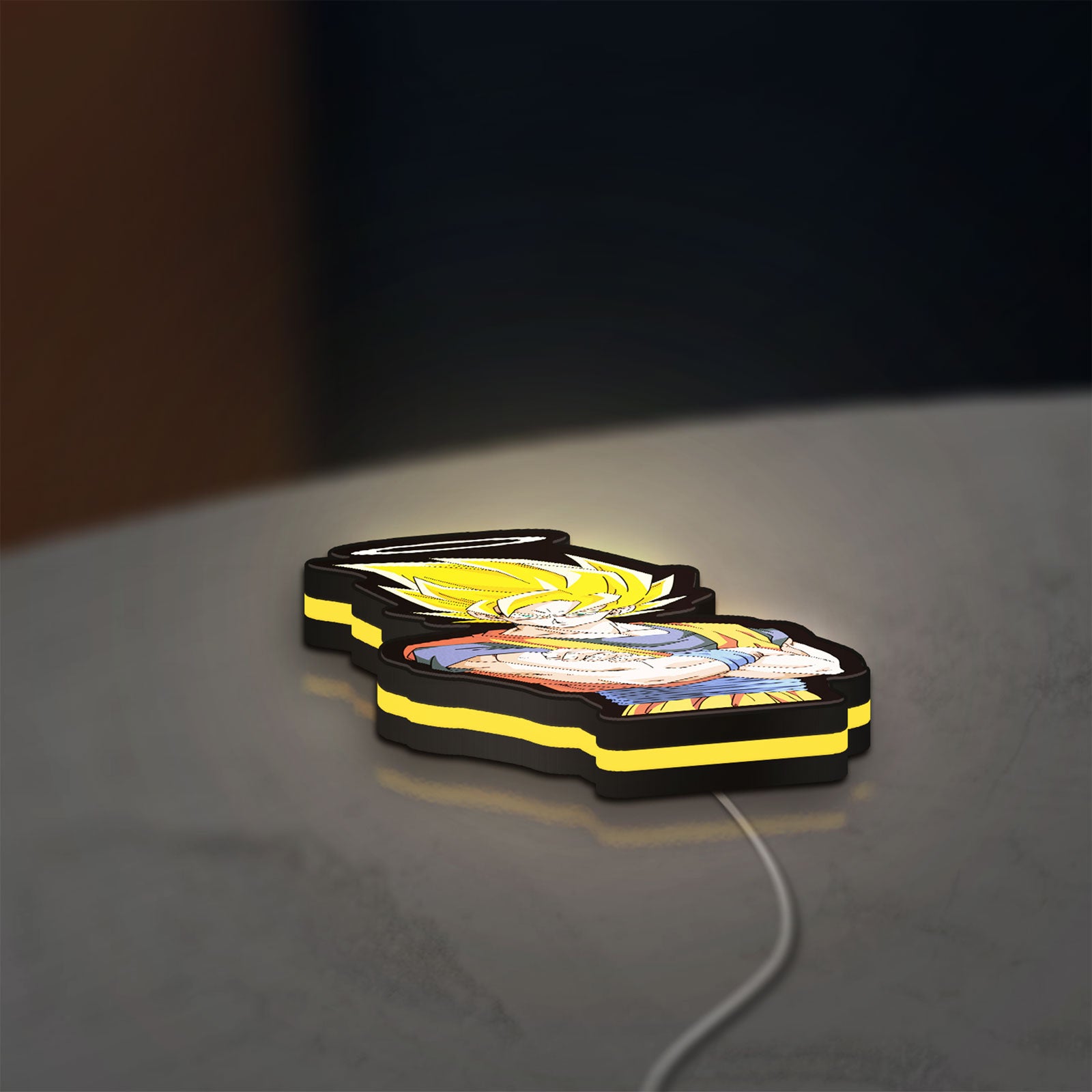 Dragon Ball Z Goku LED lightbox lying flat on a desk with yellow glow