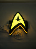 20cm Star Trek Command Insignia Glowing Wall Art - Illuminated flat lay angled view, unique wall art for desk and room decor