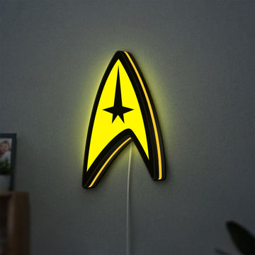 Star Trek Command Insignia LED lightbox hanging on a wall with yellow glow