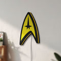 Unlit Star Trek Command Insignia LED lightbox mounted on a wall in daylight