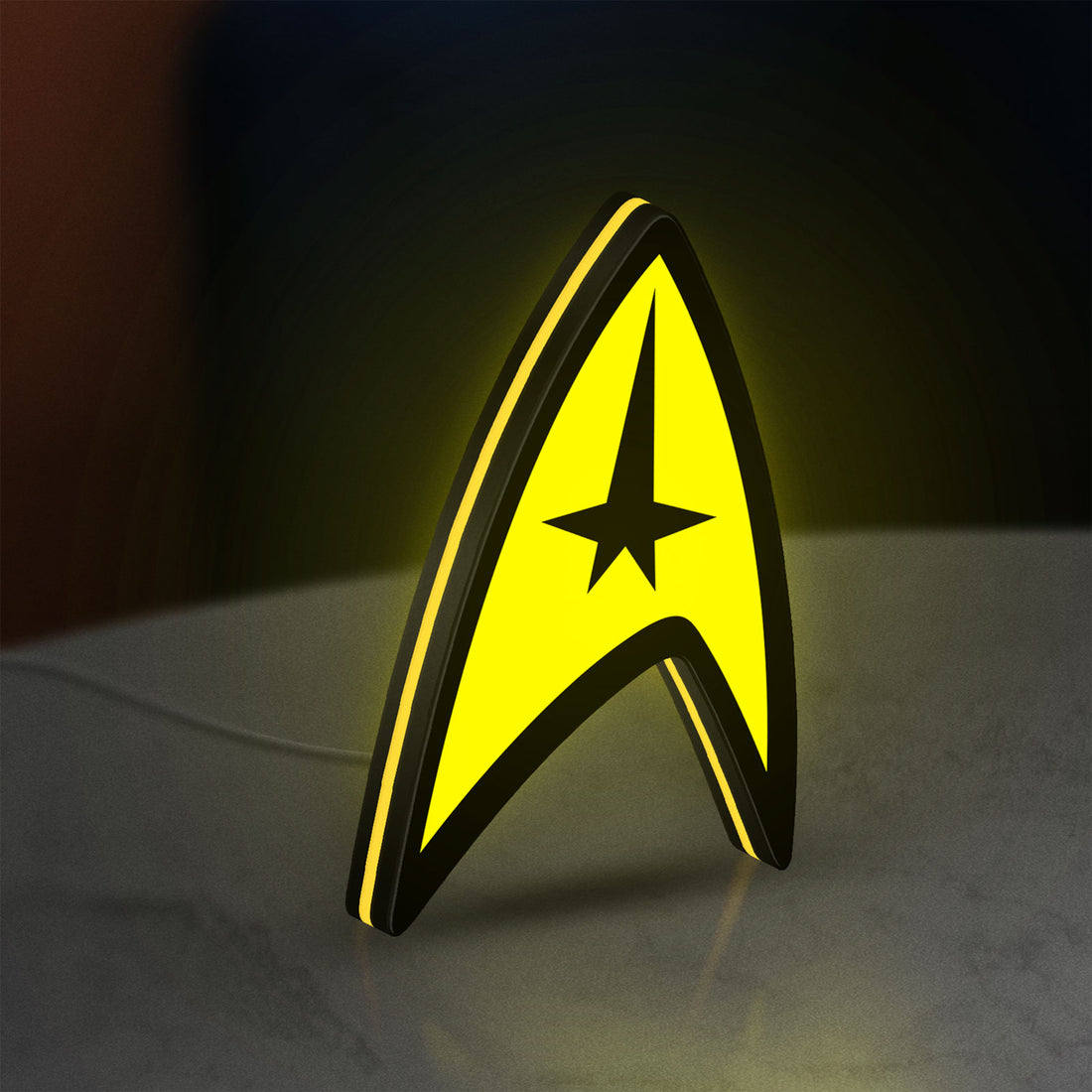 Star Trek Command Insignia LED lightbox hanging on a wall with yellow glow