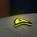 Star Trek Command Insignia LED lightbox lying flat on a desk with yellow glow