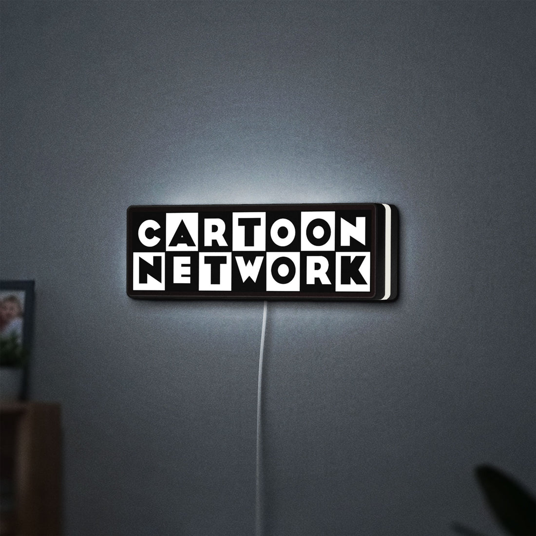 Cartoon Network LED lightbox hanging on a wall with white glow