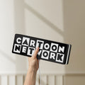 Unlit Cartoon Network LED lightbox held by hand to show size and details