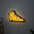 Garfield LED lightbox hanging on a wall with orange glow