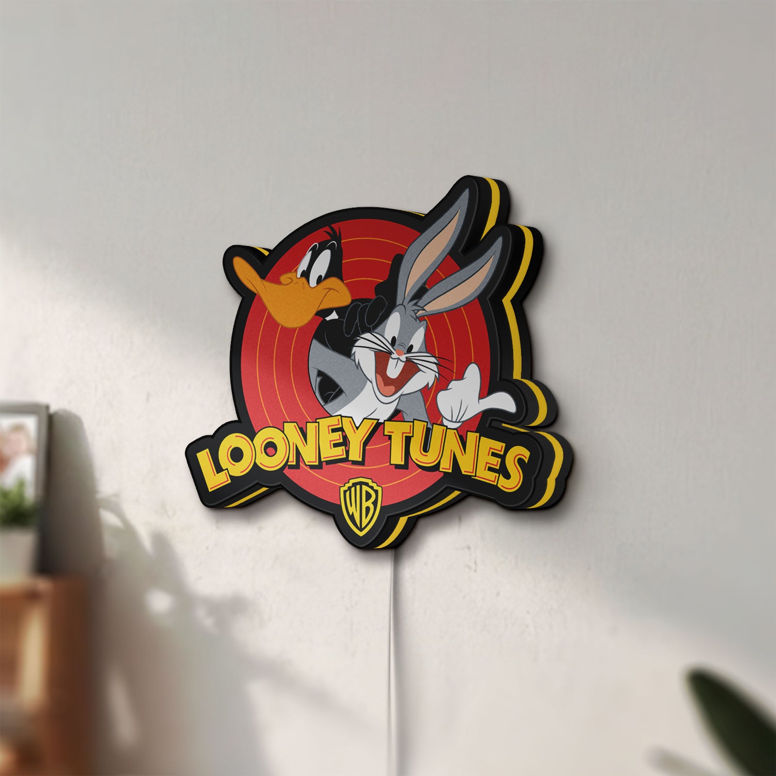 Unlit Looney Tunes LED lightbox mounted on a wall in daylight