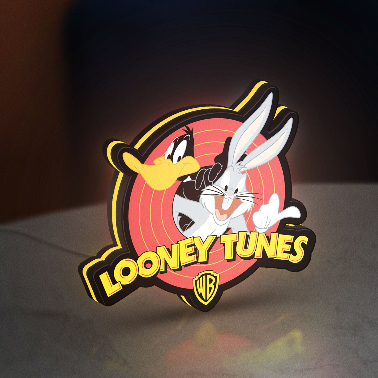 Looney Tunes LED lightbox standing on a desk from an angled side view with yellow glow