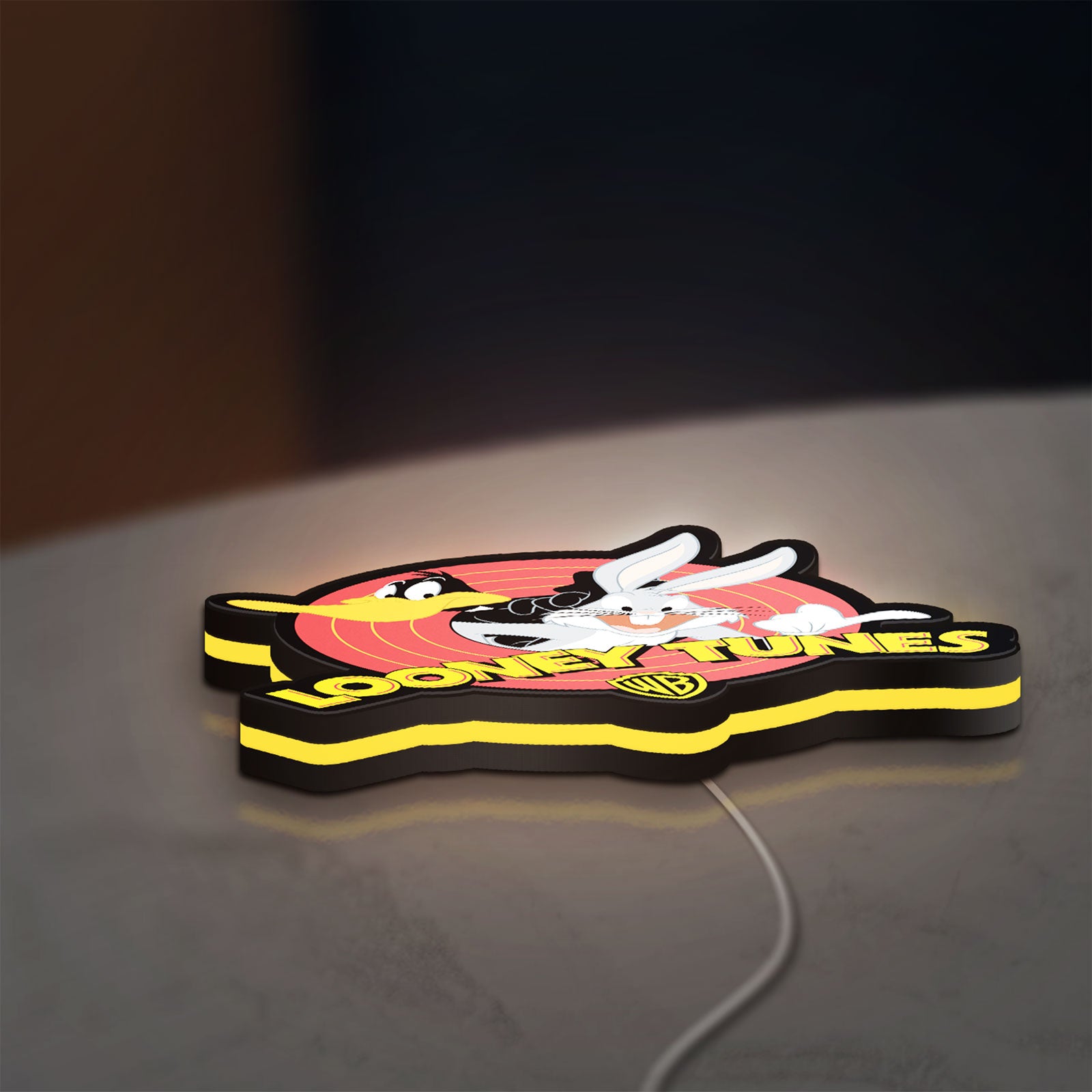 Looney Tunes LED lightbox lying flat on a desk with yellow glow