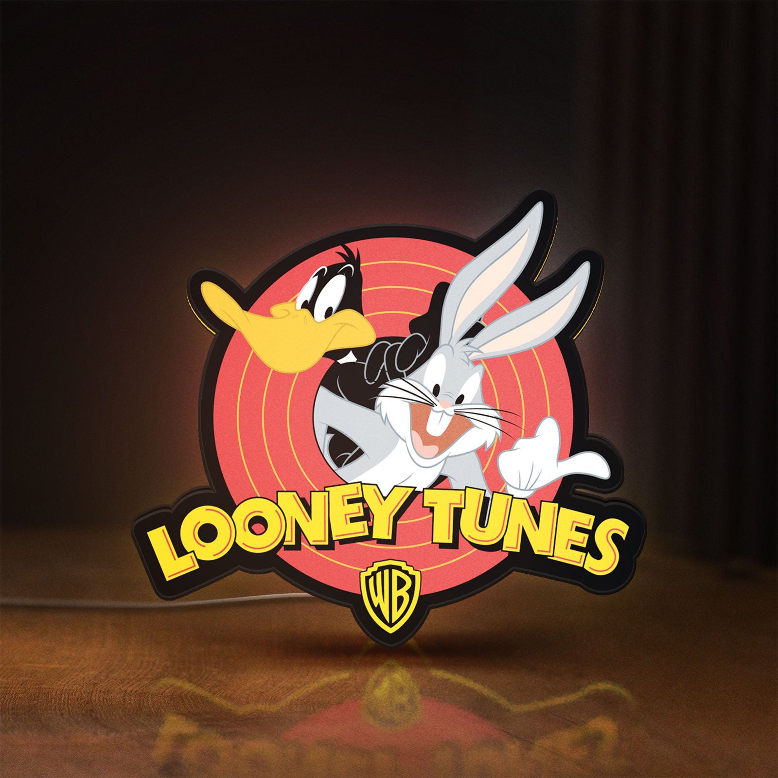 Front view of Looney Tunes LED lightbox sign glowing on a wooden desk