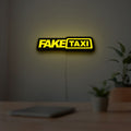 Fake Taxi LED lightbox hanging on a room wall with soft yellow light
