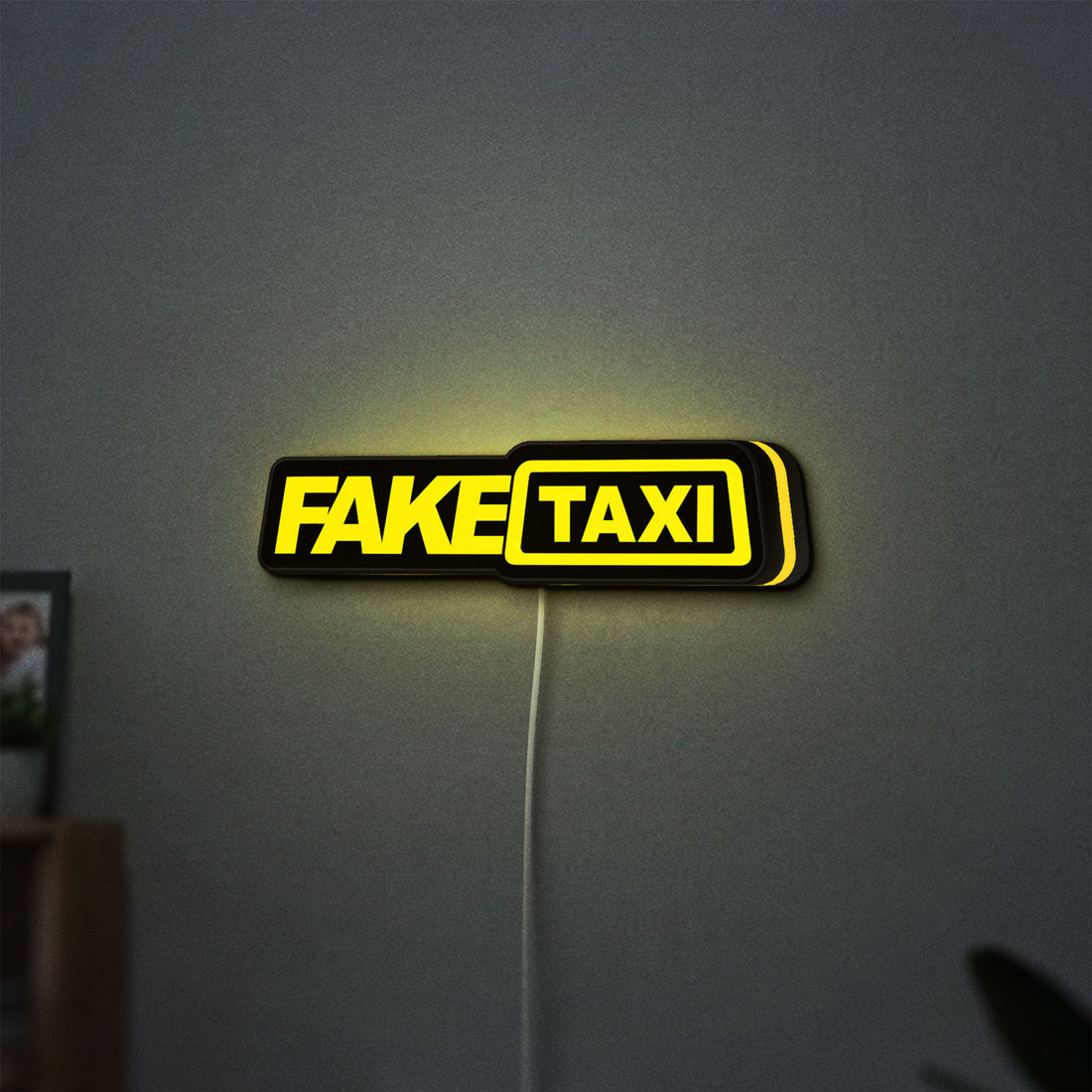 Fake Taxi LED lightbox hanging on a wall with yellow glow