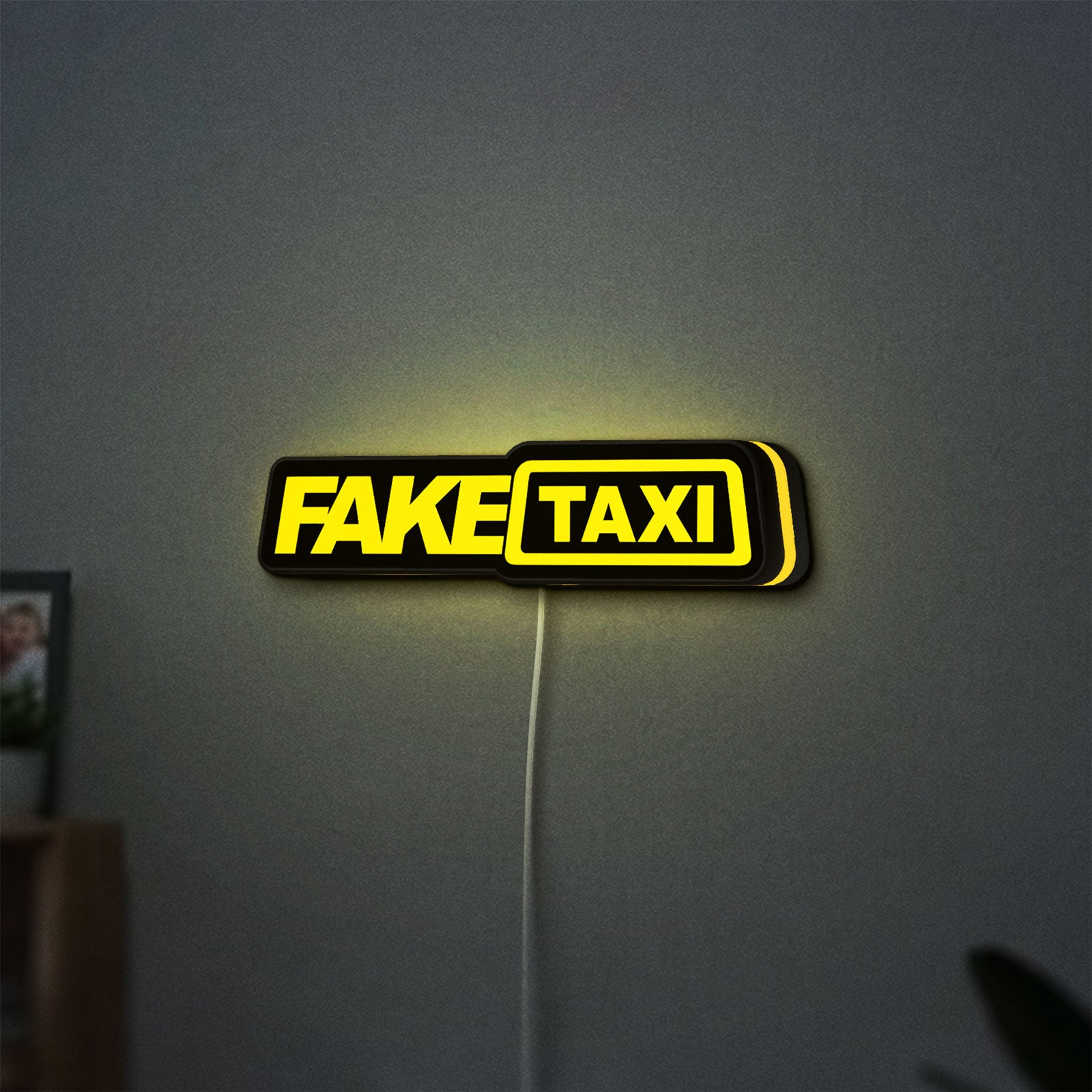 Fake Taxi LED lightbox hanging on a wall with yellow glow